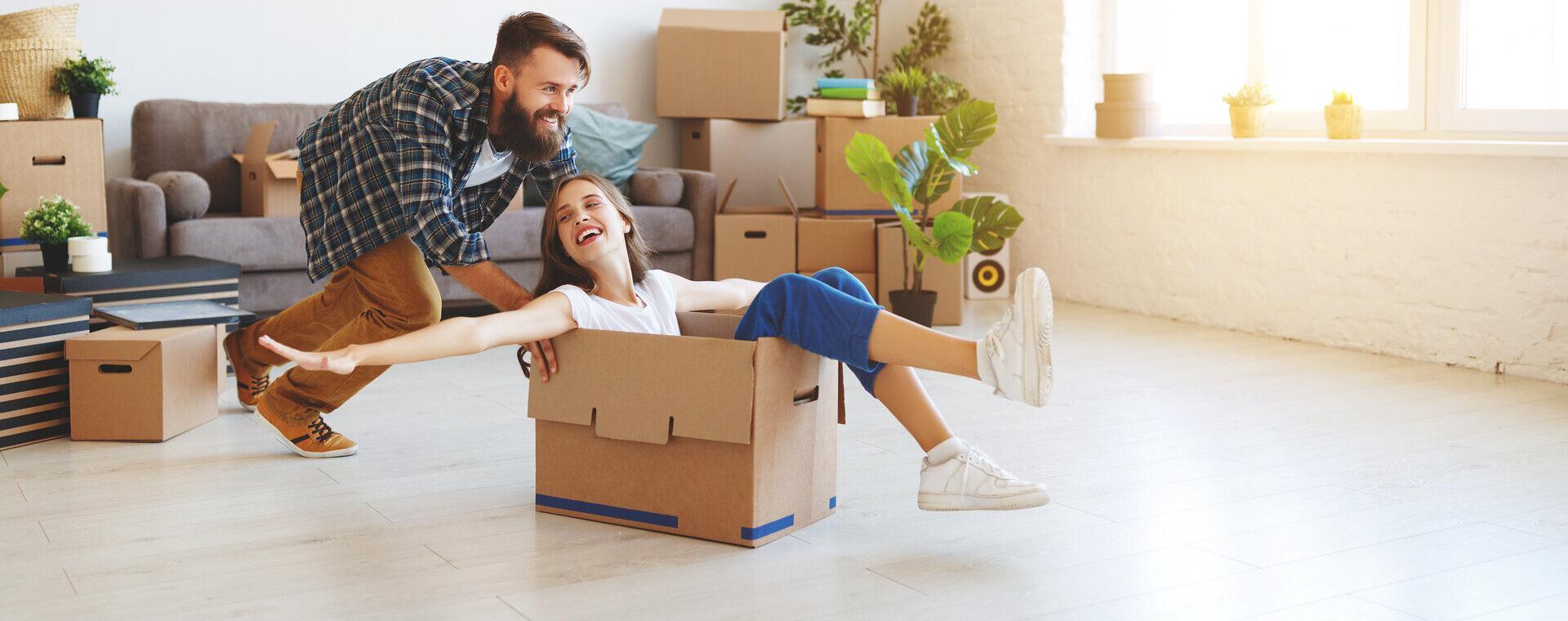 Ein glückliches junges Ehepaar zieht in eine neue Wohnung