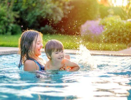 Pools kaufen: Kinder spielen lachend im Gartenpool bei Sonnenuntergang