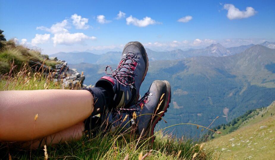 Wanderschuhe im Gras mit weitem Bergblick | Hütten mieten Österreich